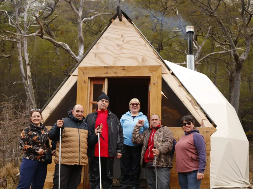 Grupo de visitantes frente al Domo Titan, refugio de montaña en Laguna Esmeralda